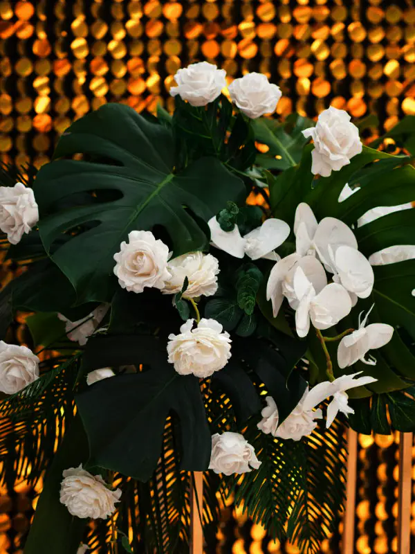 A beautifully styled wedding reception in Townsville featuring rented tropical palms and cascading greenery to create an island-inspired atmosphere.