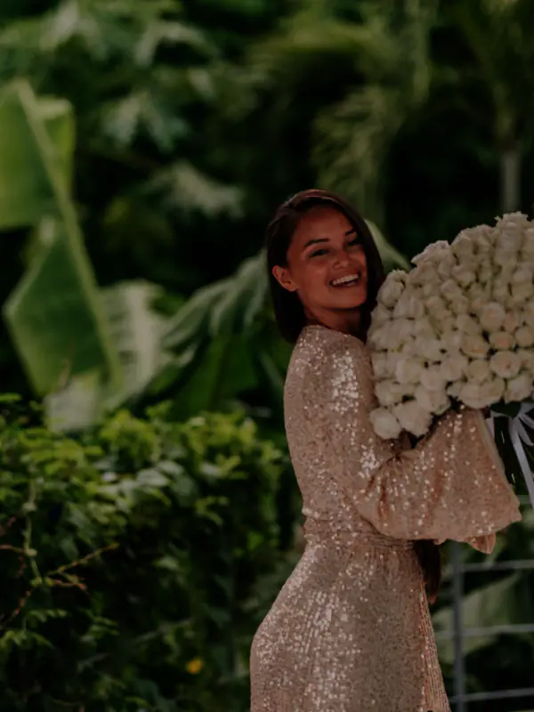 A romantic Townsville wedding ceremony featuring tall, lush palms and tropical foliage arranged as a natural altar backdrop.